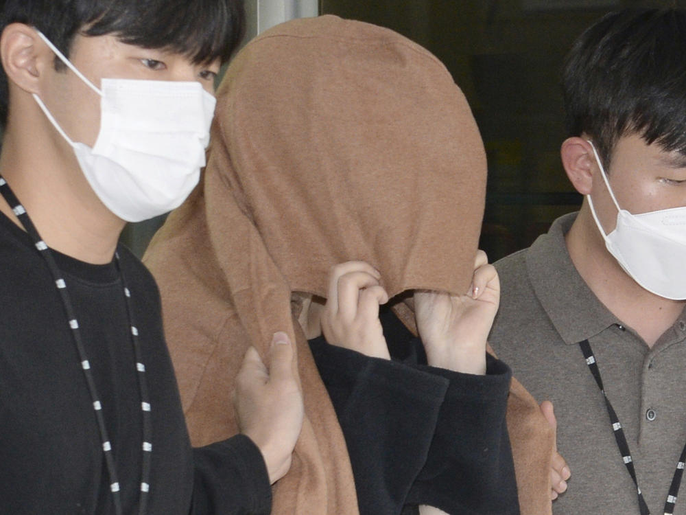 A woman, center, leaves to the Seoul Central District Prosecutors' Office at Ulsan Jungbu police station in Ulsan, South Korea, on Sept. 15, 2022.