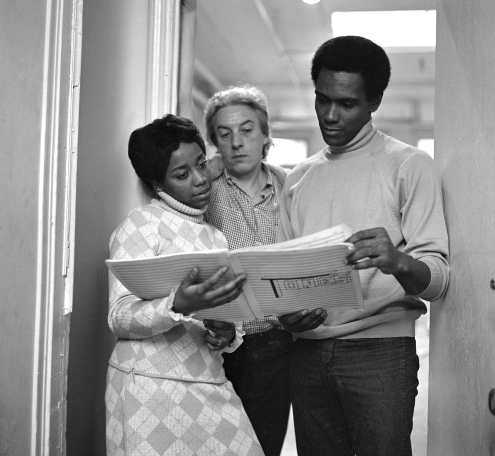 Tania León with Karel Shook (center) and Arthur Mitchell, founders of the Dance Theatre of Harlem, looking at the score of León's first ballet, <em>Tones, </em>circa 1969-1970.