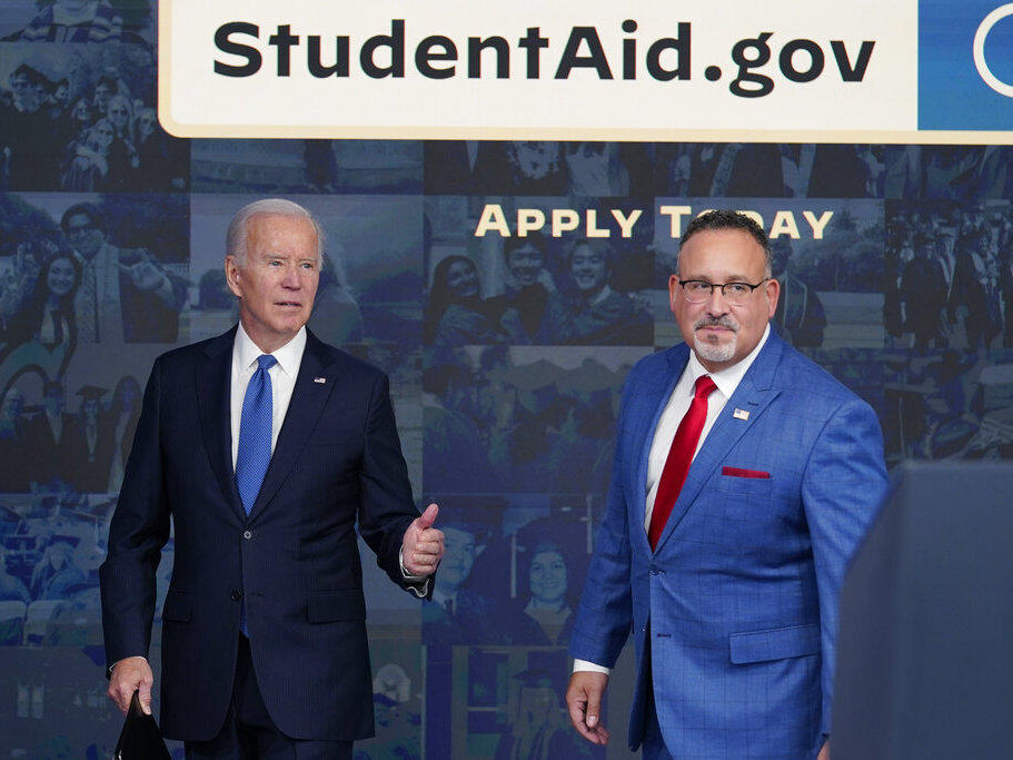 President Joe Biden answers questions with Education Secretary Miguel Cardona in October as they leave an event about the student debt relief portal.