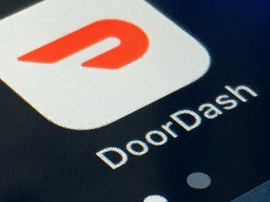 In this Feb. 27, 2020, file photo, the DoorDash app is shown on a smartphone in New York. DoorDash is cutting more than 1,200 corporate jobs, saying it hired too many people when demand for its services increased during the COVID-19 pandemic.