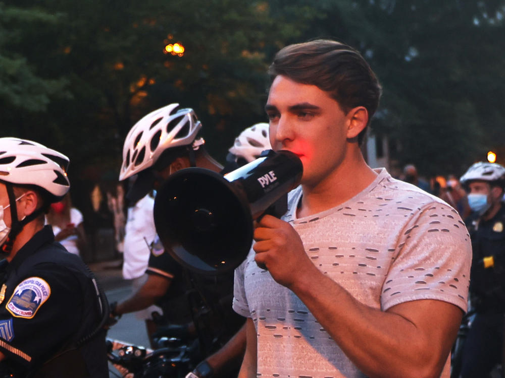 Jacob Wohl, pictured here surrounded by police officers at a 2020 protest in Washington D.C., is one of two right-wing activists who were behind a 2020 robocall scheme that targeted minority voters. Wohl will now face probation, fines and 500 hours of voter registration assistance for pleading guilty to telecommunications fraud.