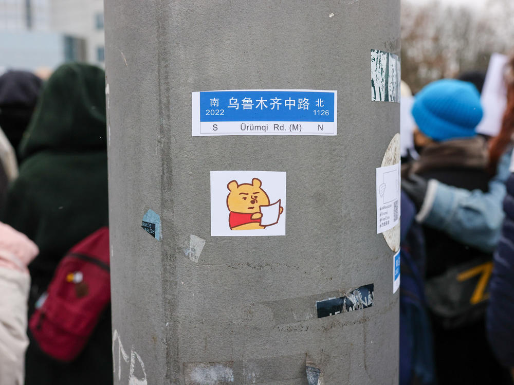 A sticker depicting Winnie the Pooh holding a blank paper was placed on a post as demonstrators protested in front of the Chinese Embassy in solidarity with protesters in China on Saturday in Berlin, Germany.