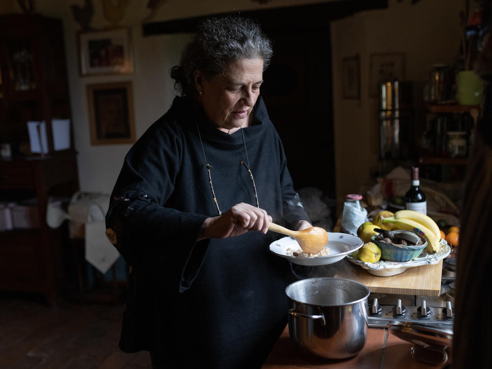 Gloria Lucchesi cooks some local beans that she prepared using the cooking containers, on Nov. 12, in San Casciano dei Bagni, Italy.