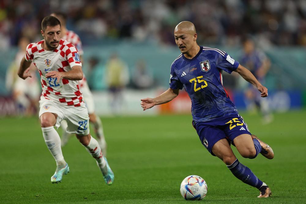 Japan forward Daizen Maeda (#25) runs with the ball during the 2022 World Cup round of 16 football match between Japan and Croatia. Maeda scored the game's first goal to give Japan a 1-0 lead at halftime at Al Janoub Stadium in Al-Wakrah, Qatar on December 5, 2022.