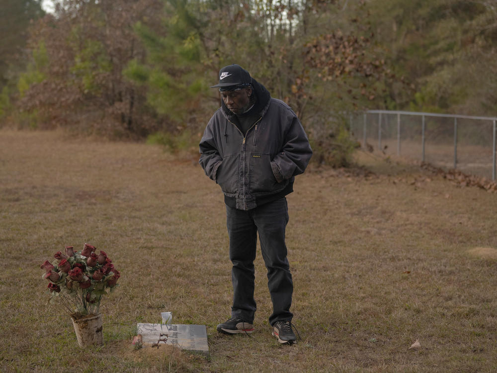 Andy Lang visits the gravesite of his sister Bertha Reed, Sunday November 20, 2022 in McIntosh, Alabama. Lang worked at the Olin Corp. chemical plant as a contract pipefitter, his sister retired after working as a lab analyst. Soon after she retired, Reed, who did not smoke cigarettes, was diagnosed with lung cancer. She died in 2017 at age 64.