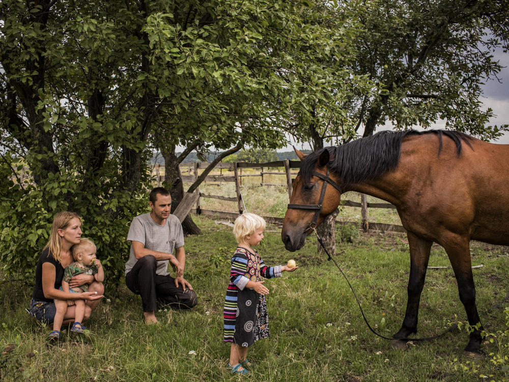 Olga and Nikolay Grinik with their son, Kirill (left), and daughter, Miroslava (right), in Avdiivka, in eastern Ukraine's Donetsk region, in July 2018. The family lived about 50 yards away from a Ukrainian front-line military position in old Avdiivka. They owned the only horse in town, Lastochka (Swallow), and made extra money giving cart rides to children in downtown Avdiivka.