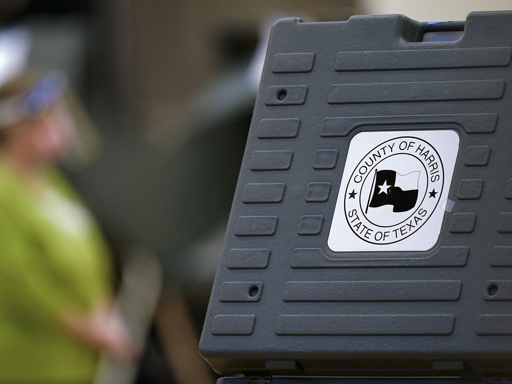 In this 2020 file photo, an election poll worker stands among voting machines in Houston. Texas state Republican leaders are accusing officials in Houston's Harris County of 