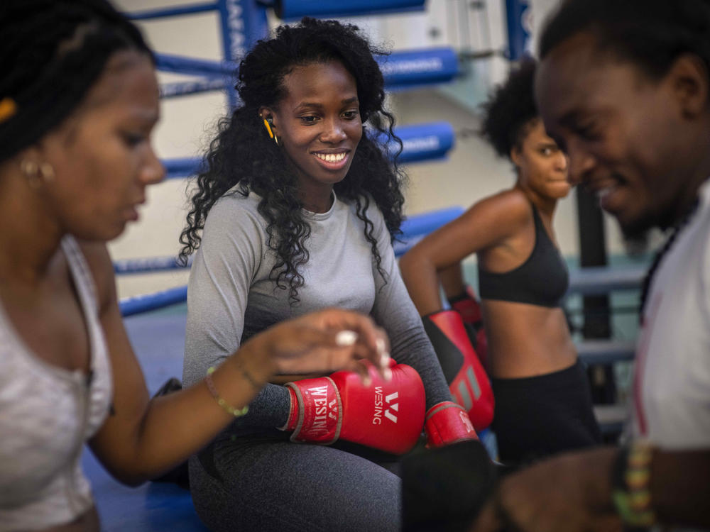 Boxer Legnis Cala, center, talks with fellow female boxers during a training session in Havana, Cuba, Monday, Dec. 5, 2022. Cuban officials announced on Monday that women boxers would be able to compete for the first time ever.