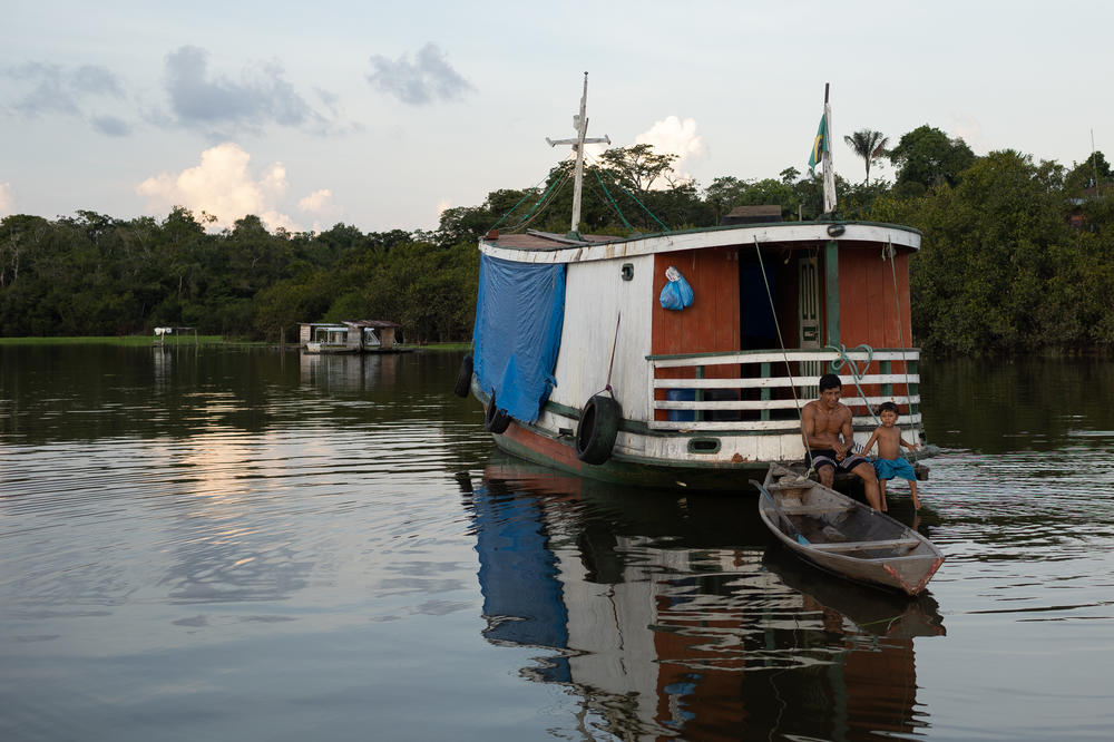 A father and son in a wooden boat on Lake Amanã on Nov. 16.