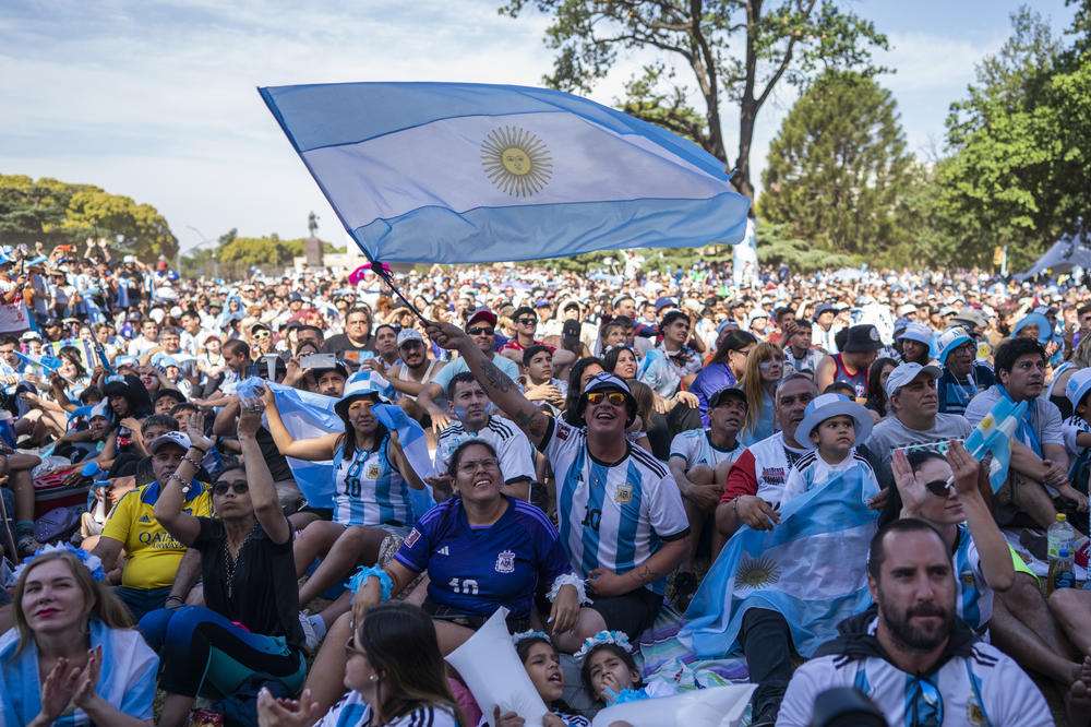 An Argentine fan waves the country's flag as he watches the 2022 World Cup match between Argentina and Australia with hundreds of other fans on Saturday, Dec. 3, at a park in Buenos Aires, Argentina. Argentina won the match, 2-1.