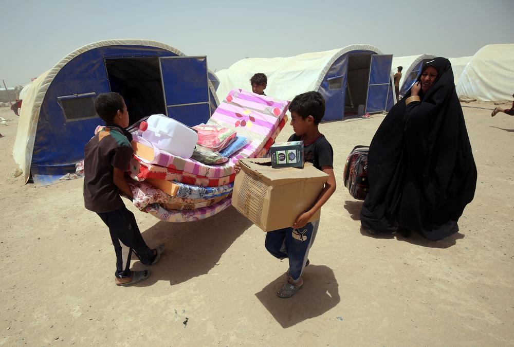 Iraqis displaced from the city of Fallujah collect aid distributed by the Norwegian Refugee Council, which has been awarded this year's $2.5 million Conrad N. Hilton Humanitarian Prize.