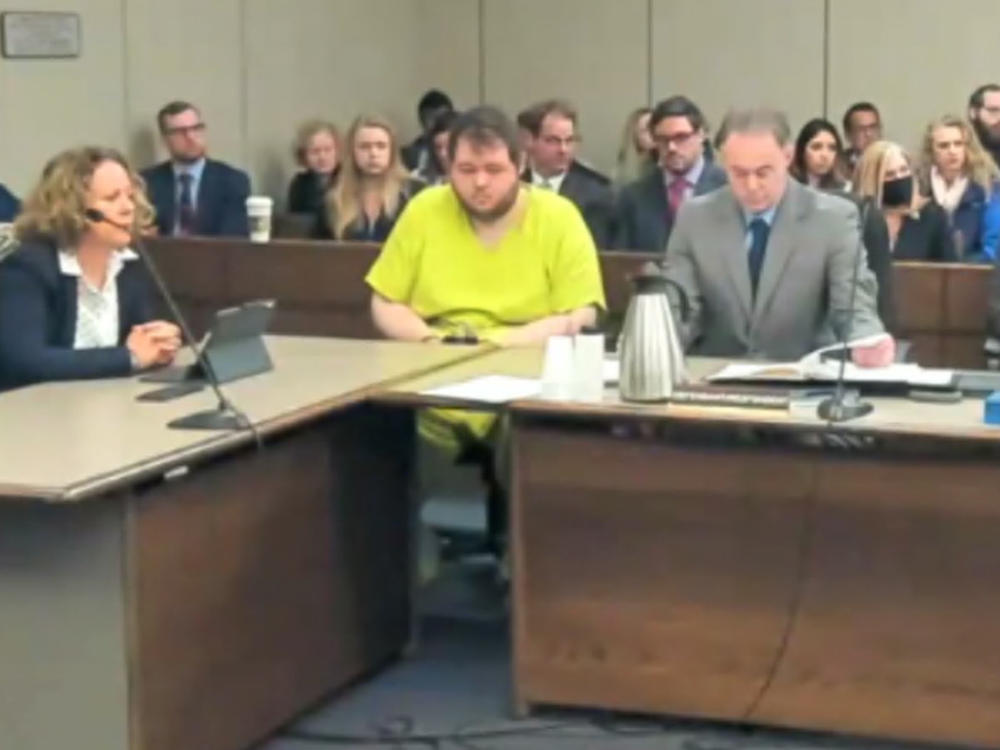 In this image taken from El Paso County District Court video, Anderson Lee Aldrich, 22 (center) sits during a court appearance in Colorado Springs, Colo., on Tuesday. According to newly unsealed court documents, Aldrich was also charged with felony crimes in June 2021, but the case was dismissed.