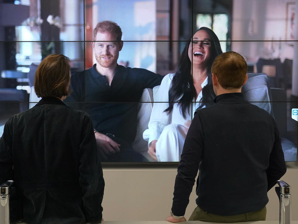 Office workers in London, watch the Duke and Duchess of Sussex's controversial documentary being aired on Netflix Thursday, Dec. 8, 2022.