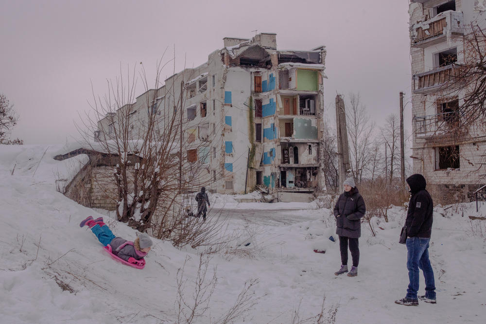 A girl sleds next to destroyed buildings in Borodianka on Sunday.