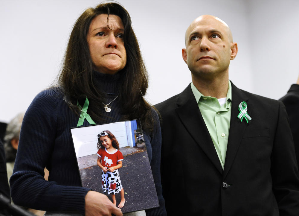 At a press conference one month after the shooting, Jennifer Hensel holds a portrait of her daughter, Avielle Rose Richman, who was among those killed at the Sandy Hook Elementary School. Beside her is her husband, Jeremy, who worked tirelessly for brain research into the causes of violence. Jeremy took his own life in 2019.