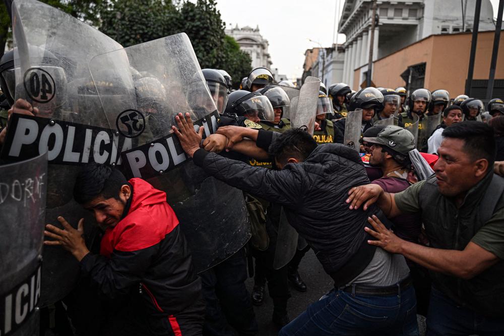 People clash with riot police during a demonstration demanding the release of ex-President Pedro Castillo and the closure of the Peruvian Congress in Lima on Thursday, a day after Castillo's impeachment.