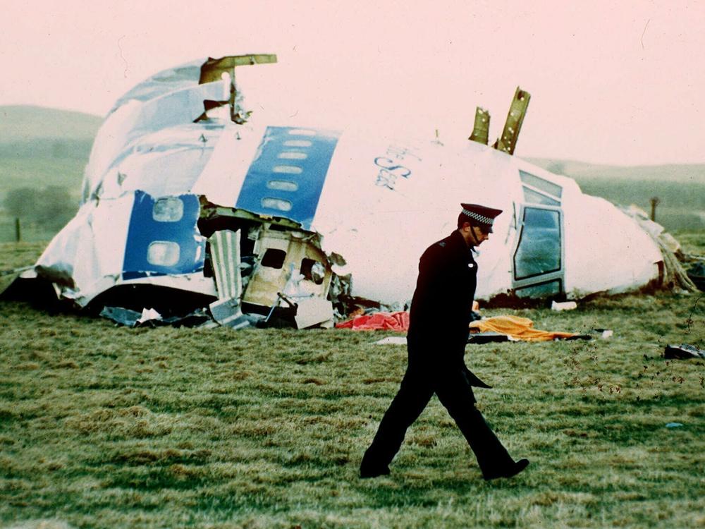 A police officer walks by the nose of Pan Am Flight 103 in a field near the town of Lockerbie, Scotland in 1988.