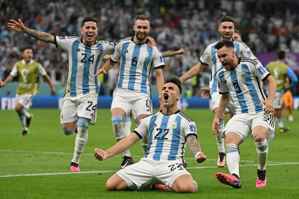 Argentina forward Lautaro Martínez (No. 22) celebrates after scoring in a penalty shoot-out to defeat the Netherlands in a 2022 World Cup quarterfinal match on Friday, Dec. 9, at the Lusail Stadium, north of Doha, Qatar.