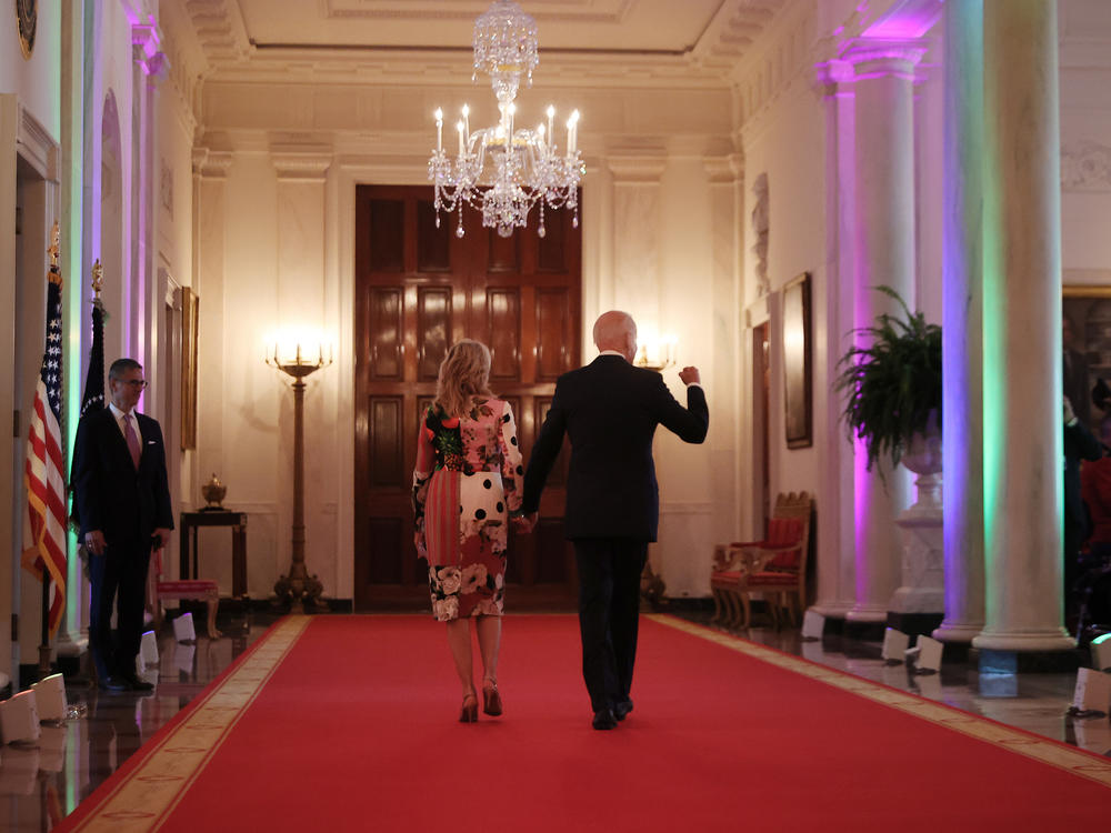 President Biden and first lady Jill Biden walk through the Cross Hall of the White House lit with rainbow colors following an event commemorating LGBTQ+ Pride Month in the East Room last year.