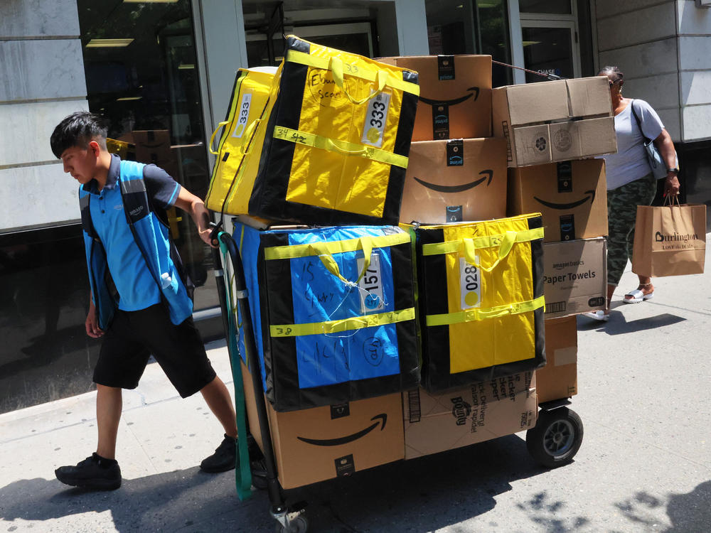 An Amazon worker pulls a cart of packages for delivery in New York City in July. A promotion that enabled shoppers to tip workers last week maxed out in less than 48 hours.