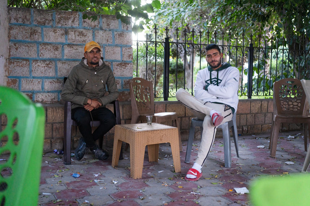 Friends Bahadine Ensiri (left) and Wajdi Naji sit together drinking coffee and smoking at a park, neither plan to vote in the election.