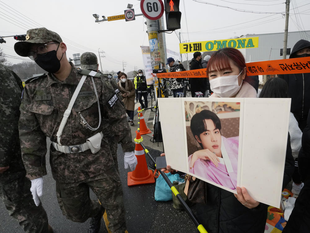 A fan waits for K-pop band BTS's member Jin to arrive before he enters the army to serve near an army training center in Yeoncheon, South Korea, on Tuesday.