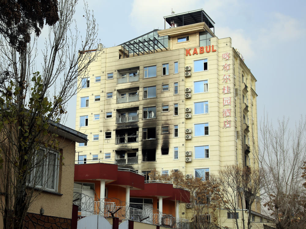 A hotel building sits charred after an attack in Kabul, Afghanistan, Tuesday, Dec. 13, 2022. The militant Islamic State group has claimed responsibility for a coordinated attack on the Chinese-owned hotel in Afghanistan's capital that left three assailants dead and at least two of the hotel guests injured as they tried to escape by jumping out from a window.