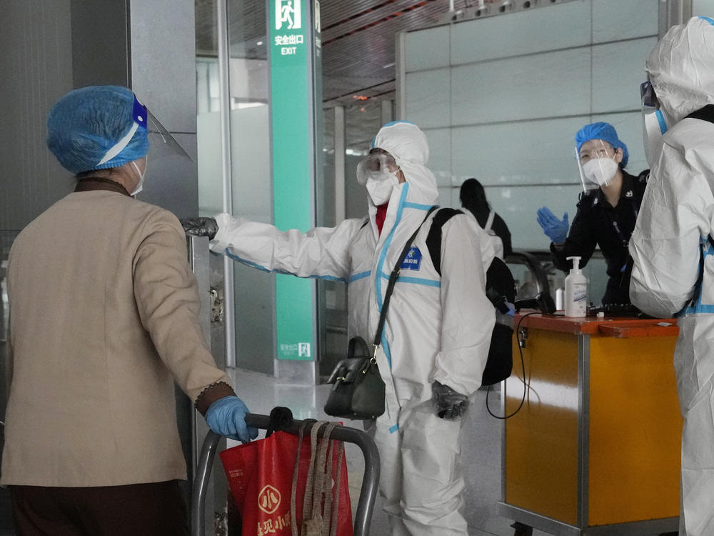 Passengers in protective gear are directed to a flight at a Capital airport terminal in Beijing, Tuesday, Dec. 13, 2022.