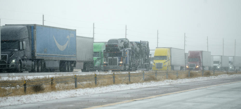Tractor trailers are stacked up on the shoulder along the eastbound lanes of Interstate 70 near East Airpark Road on Tuesday in Aurora, Colo.