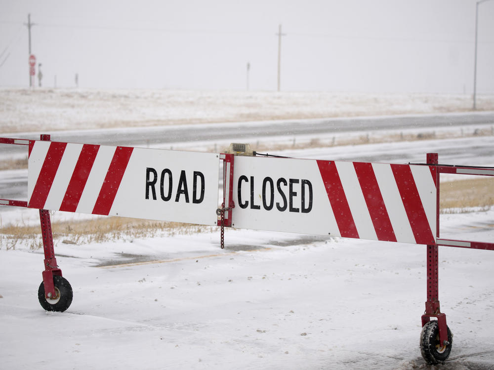 The gate is closed on an on ramp to the eastbound lanes of Interstate 70 in Aurora, Colo., on Tuesday. A massive winter storm has closed roads throughout northeast Colorado.