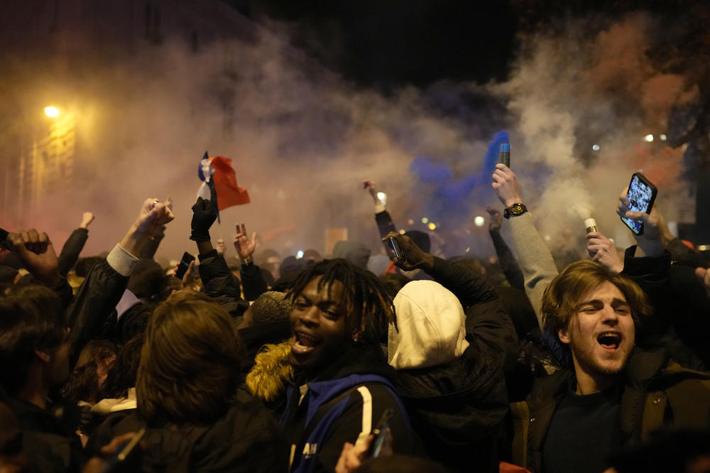 France's fance react next to the Arc de Triomphe on the Champs-Élysées avenue at the end of a World Cup semifinal match with Morocco on Wednesday, Dec. 14, in Paris.