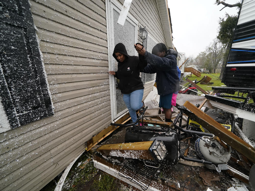People help each other through the rubble after a tornado tore through the area in Killona, La., about 30 miles west of New Orleans in St. James Parish, Wednesday, Dec. 14, 2022.