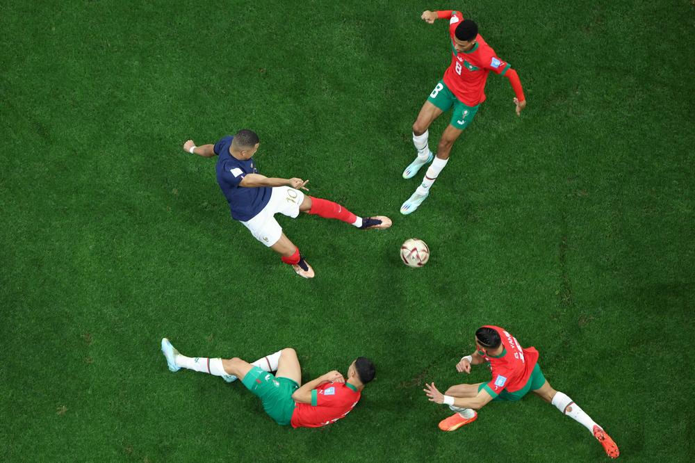 French forward Kylian Mbappé (C) fights for the ball with Morocco's midfielder Azzedine Ounahi (top) and defender Jawad El Yamiq (R) during a 2022 World Cup semifinal match on Wednesday, Dec. 14, at the Al-Bayt Stadium in Al Khor, north of Doha, Qatar.