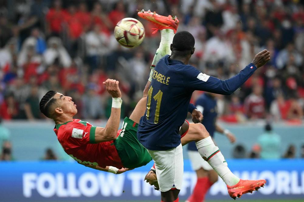 Moroccan defender Jawad El Yamiq (No. 18) attempts a shot as he's marked by French forward Ousmane Dembélé (No. 11) during a 2022 World Cup semifinal match on Wednesday, Dec. 14, at the Al-Bayt Stadium in Al Khor, Qatar. The attempted shot almost changed the course of the match.