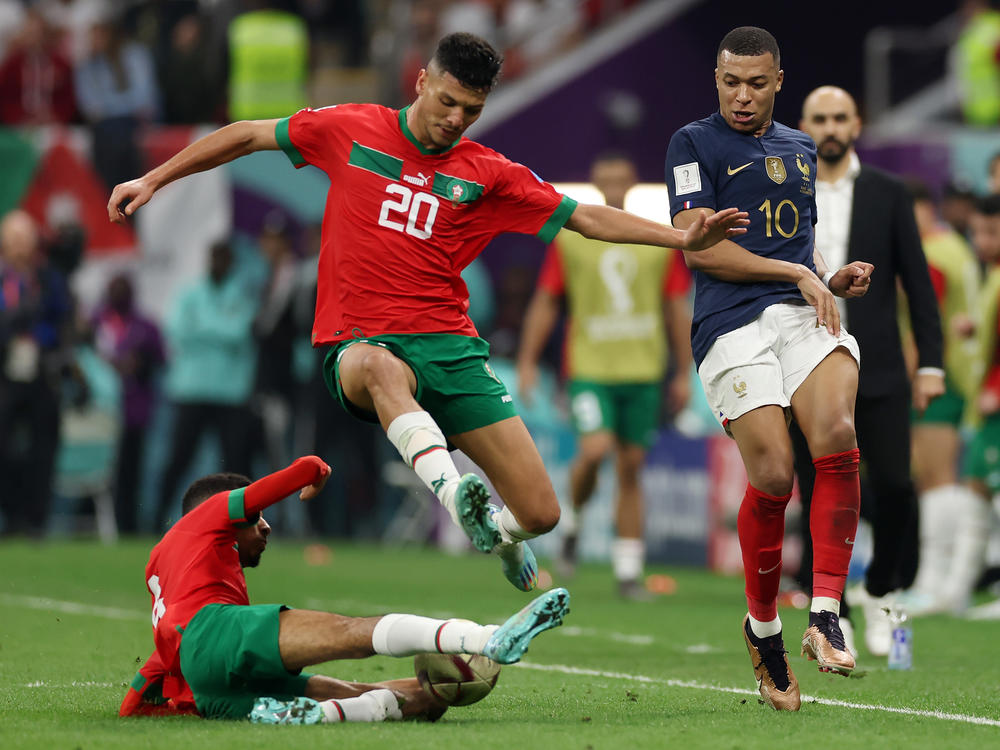 Kylian Mbappe (#10) of France competes for the ball against Achraf Dari (#20) and Azzedine Ounahi (#8) of Morocco during the World Cup semifinal match on December 14, 2022 in Al Khor, Qatar.