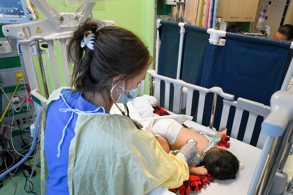 A staff member at Helen DeVos Children's Hospital cares for nine-month-old Santiago Botello Rodriguez on December 7. Santiago was transferred to the hospital the night before. DeVos Children's is receiving so many transfer requests, they can't take every one. 