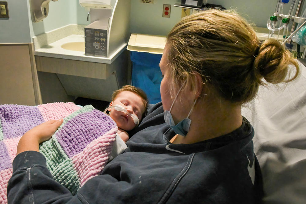Caitlyn Houston kisses her seven-week-old daughter, Parker, as they wait in the Emergency Department for a bed to open up, December 7th, 2022, Corewell Health Helen DeVos Children's Hospital in Grand Rapids, Michigan.