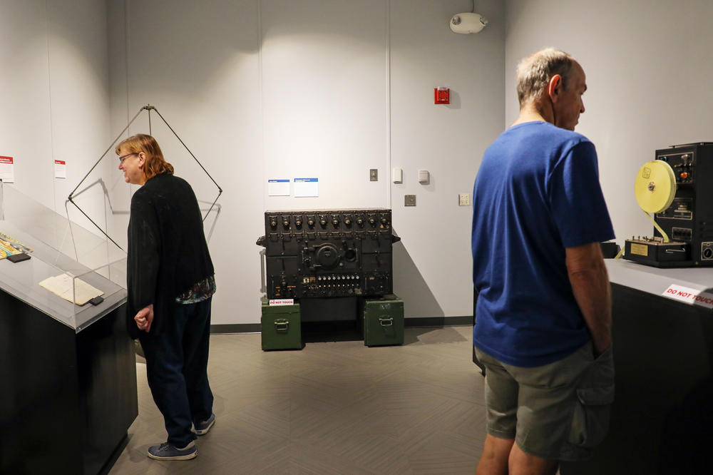 Visitors peruse the artifacts on display. In the back of the room is the device codenamed the Russian Fish.