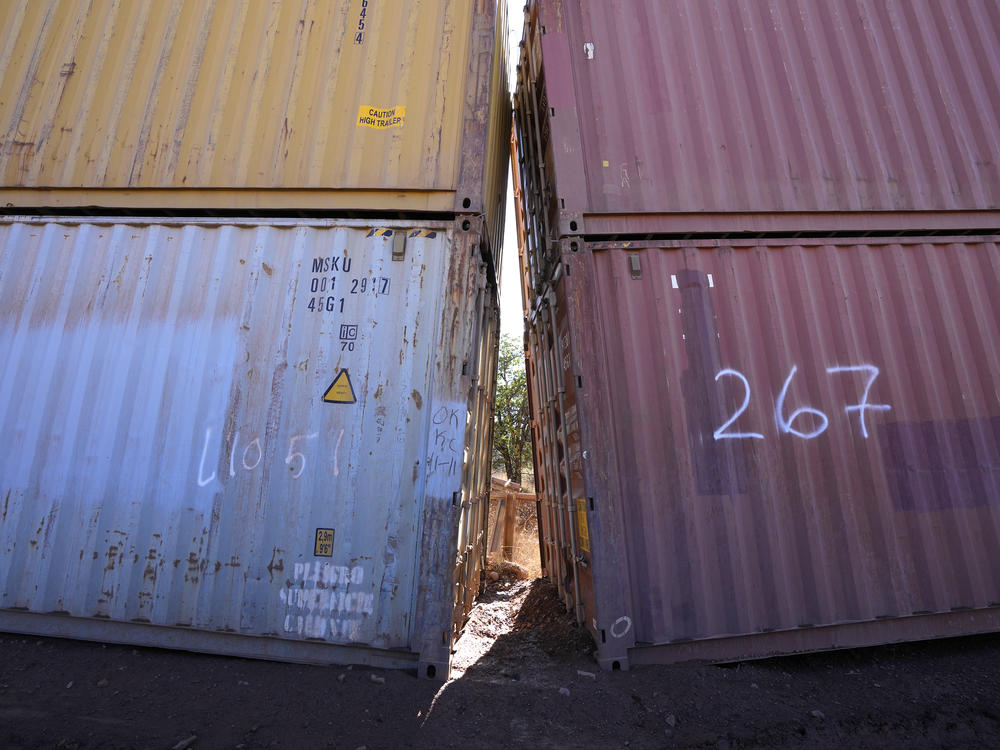 An awkward gap is shown between shipping containers at the bottom of a wash along the border where shipping containers create a wall between the United States and Mexico in San Rafael Valley, Ariz., on Dec. 8, 2022.