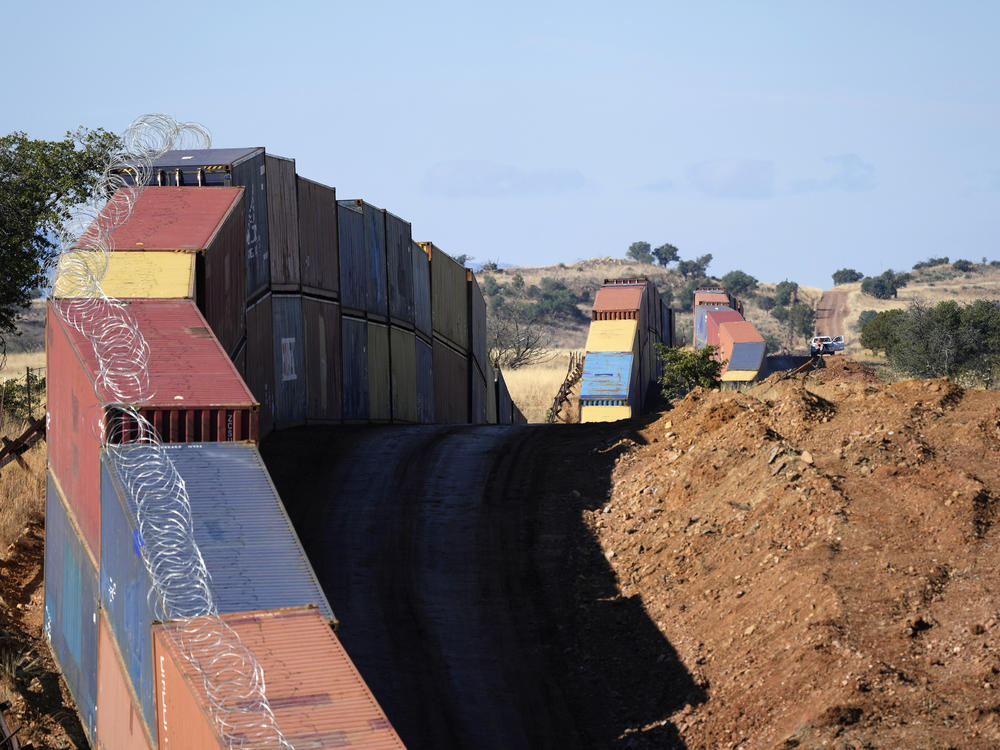 A long row of double-stacked shipping containers provide a new wall between the United States and Mexico in the remote section of San Rafael Valley, Ariz., on Dec. 8, 2022.