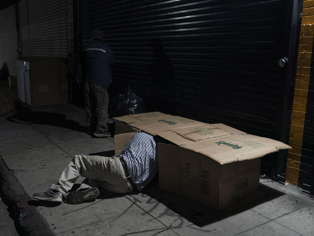 David Hernandez, 62, crawls into his bed made with cardboard boxes in Los Angeles last week. Los Angeles Mayor Karen Bass has declared a state of emergency to grapple with the city's homeless crisis.