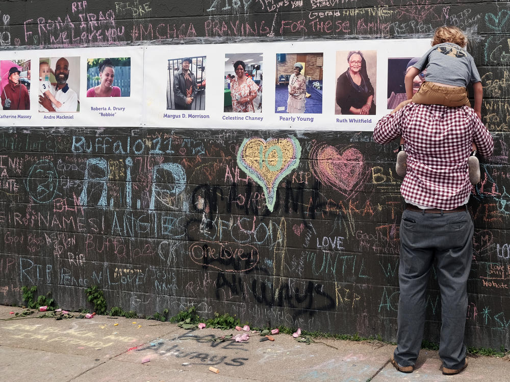 People gather at a memorial for the shooting victims outside of Tops grocery store on May 20, 2022 in Buffalo, N.Y.
