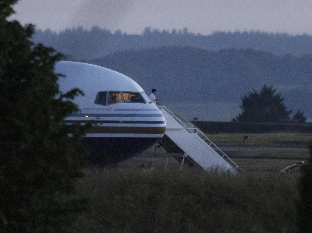 A pilot gestures from the grounded EC-LZO Boeing 767 flight, initially meant to deport Rwandan asylum-seekers, at Boscombe Down Air Base in Boscombe Down, England, on June 14. The flight taking asylum-seekers from the U.K. to Rwanda was grounded at the last minute, after the intervention of the European Court of Human Rights.