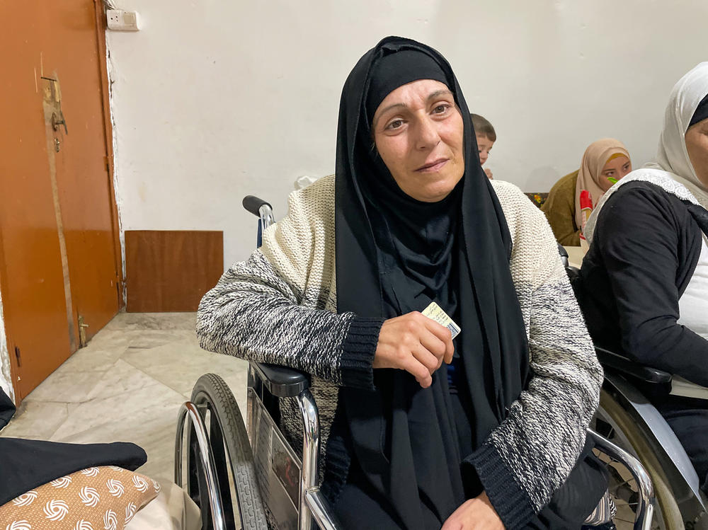 Zahra Khaled, 53, sits in a wheelchair in the apartment she shares with her sister in Tripoli, Lebanon, on Nov. 23. Khaled has lost a leg to diabetes and needs to pay for continued medical care, but is unable to access her savings.