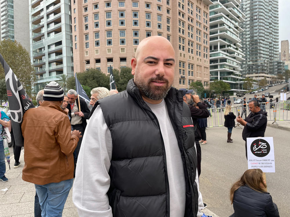 Ibrahim Abdallah, spokesperson for the Cry of the Depositors movement, stands at a protest outside a hotel hosting a conference for bankers in Beirut on Nov. 24. Abdallah says he has millions of dollars frozen in Lebanese banks. These days, he says, he can't even afford to take his son for dinner.