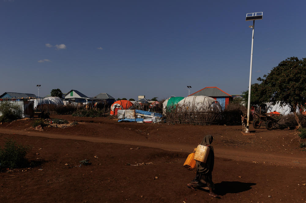 A woman walks to collect water from a water station at a camp for displaced people in Baidoa on Tuesday.