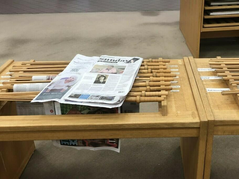 A copy of <em>The Birmingham News</em> rests on a rack at the downtown public library in Birmingham, Ala. The company that runs the newspaper and two sister papers says it will permanently stop print publication after Feb. 26, 2023.