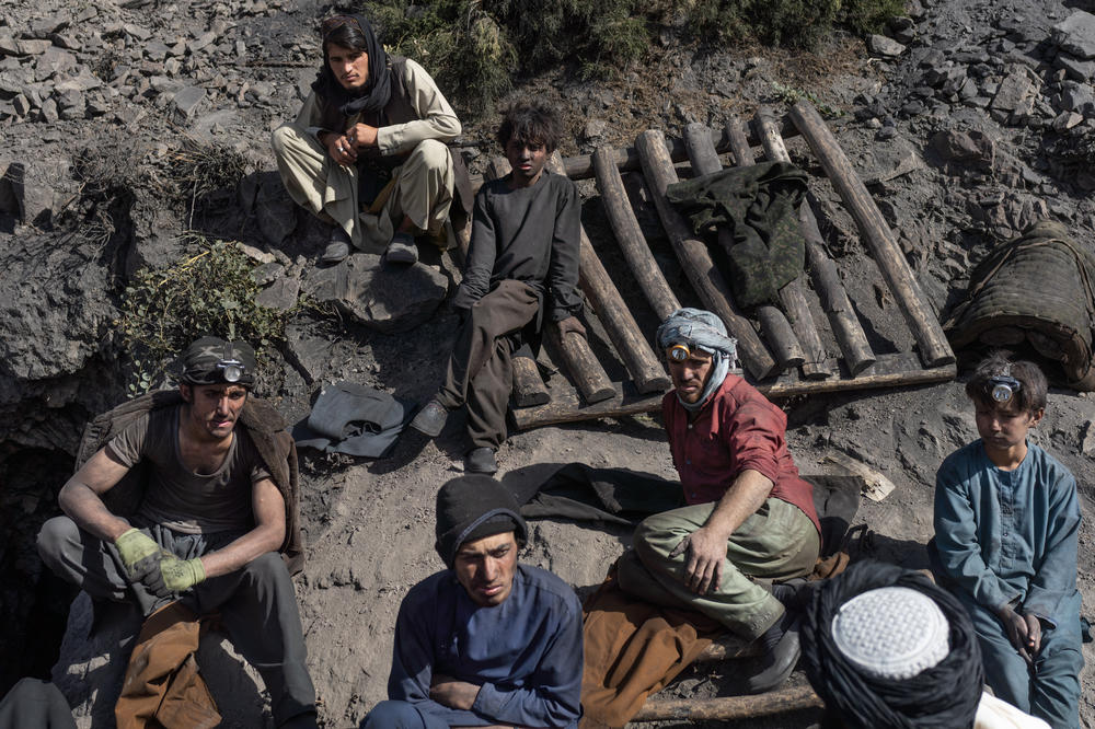 A group sits outside the mine after a day's shift is over.