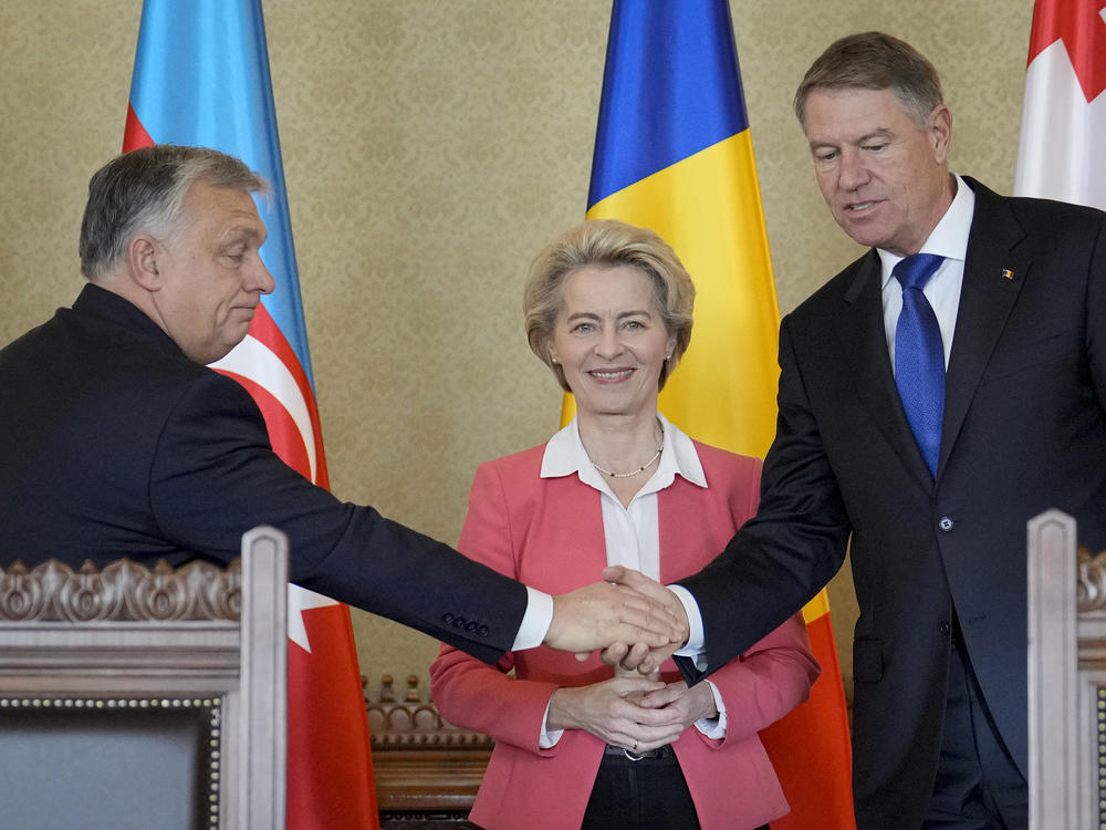 Hungarian Prime Minister Viktor Orban shakes hands with Romanian President Klaus Iohannis as European Commission President Ursula von der Leyen smiles at the Cotroceni presidential palace in Bucharest, Romania, Saturday, Dec. 17, 2022.