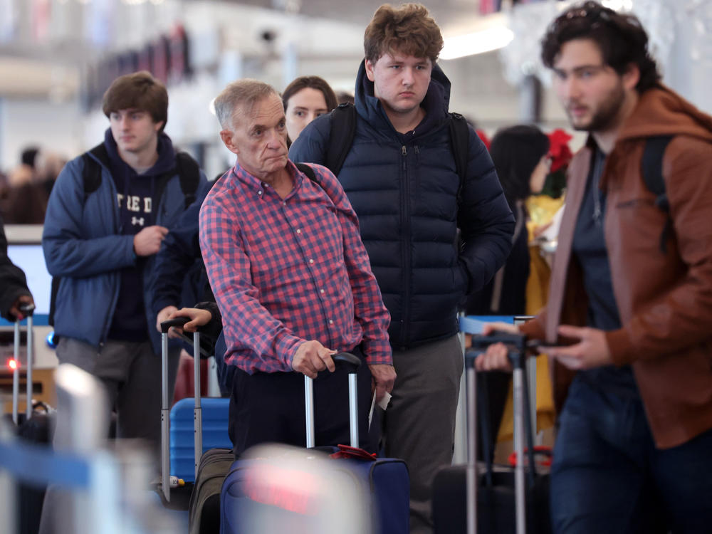 Travelers arrive for flights at O'Hare International Airport in Chicago on Dec. 16.